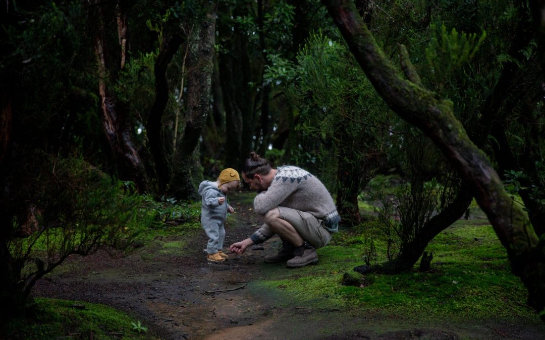 father with cute little child in mystic green woods